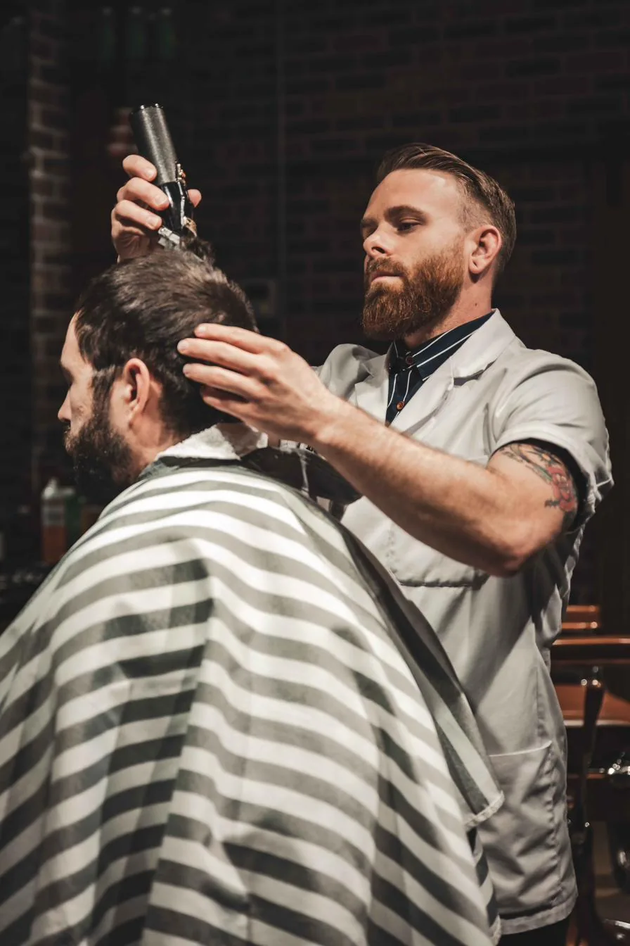 A City Barbers barber cutting a client’s hair with clippers