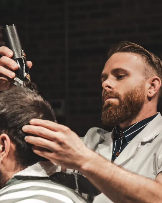 A barber combing a client’s hair