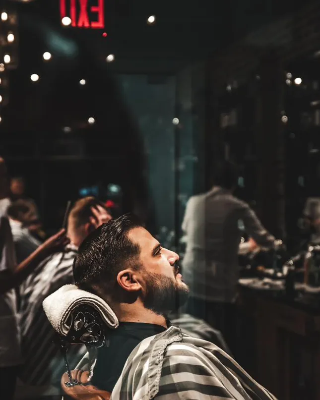 A bearded client relaxing in the barber chair