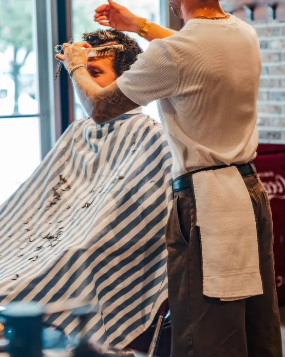 A barber at work by the shop’s front window