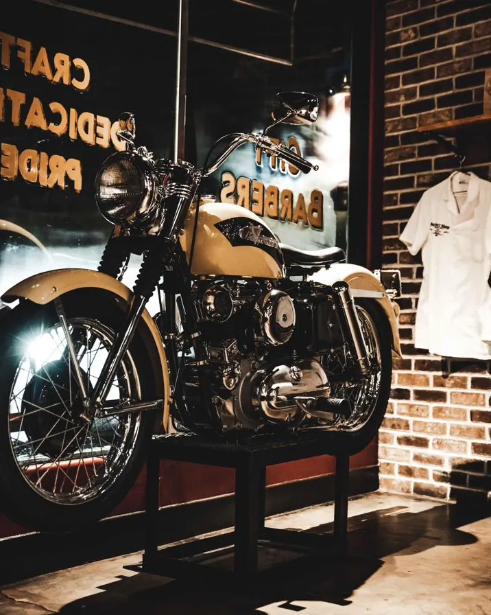A vintage motorcycle and City Barbers shirts inside the shop
