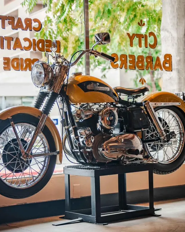 A vintage motorcycle in the front window during the day