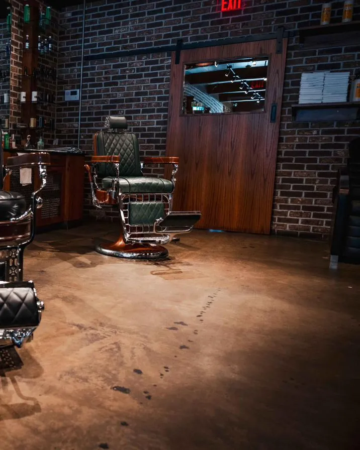 Barber chairs on the shop floor, with a green chair near the back door
